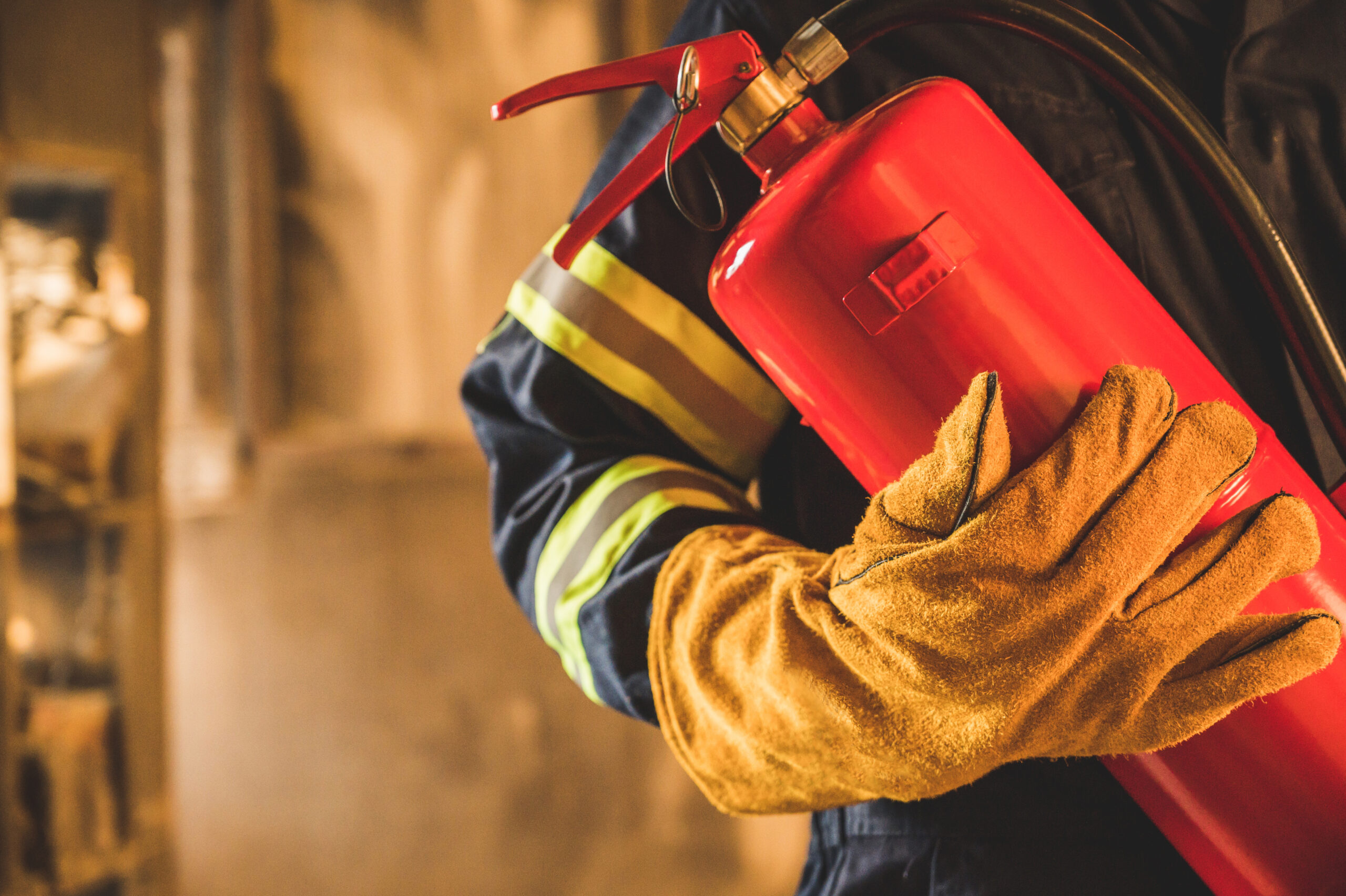 Close up hand Fireman,Firefighter holding the fire extinguisher.